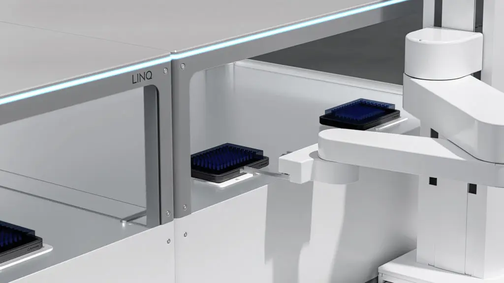 A close-up image of Automata LINQ's robotic arm moving to pick up a well plate from the transport layer.