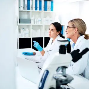 2 female scientists looking at a screen and smiling