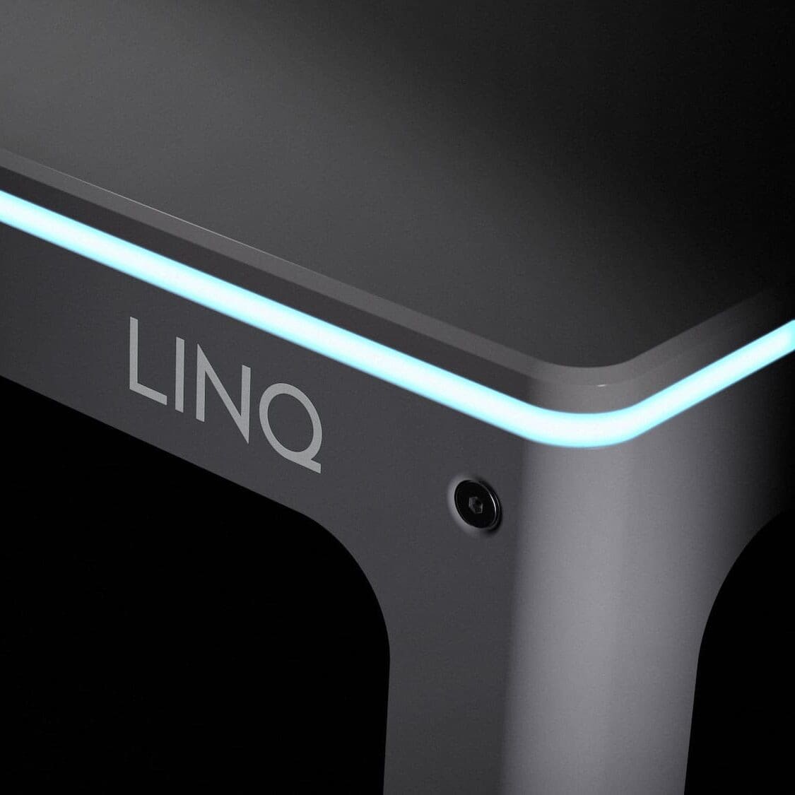 A dark image of the Automata LINQ bench that shows the name 'LINQ' on the front of it. There is a light blue LED light around the edge of the bench.